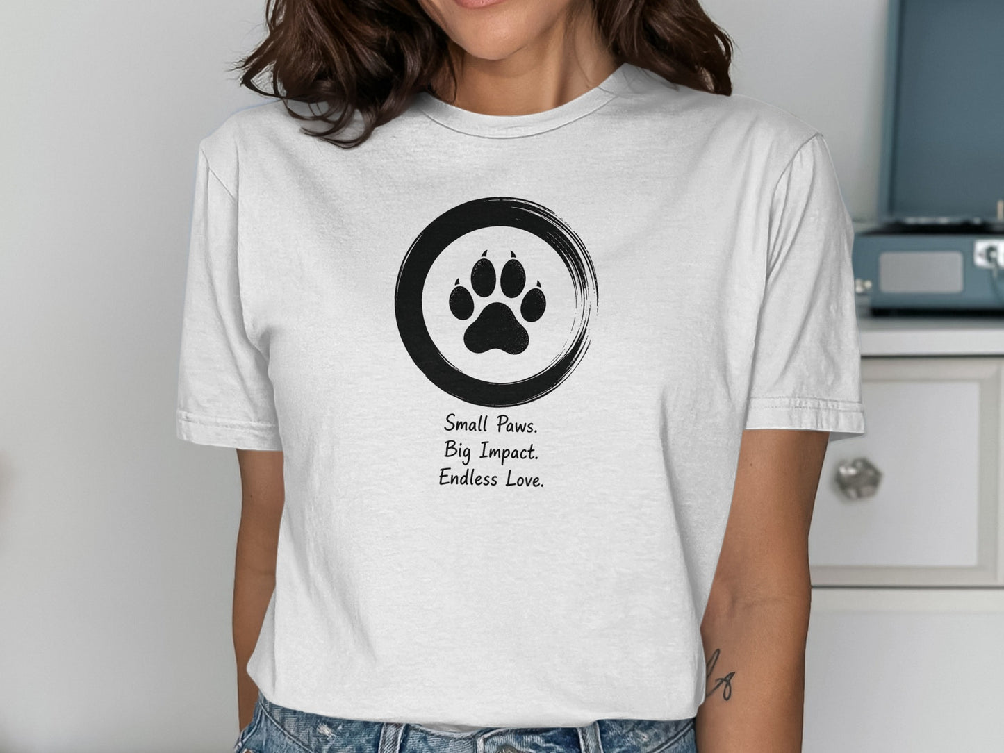White t-shirt with black paw print and "Small Paws. Big Impact. Endless Love." text.