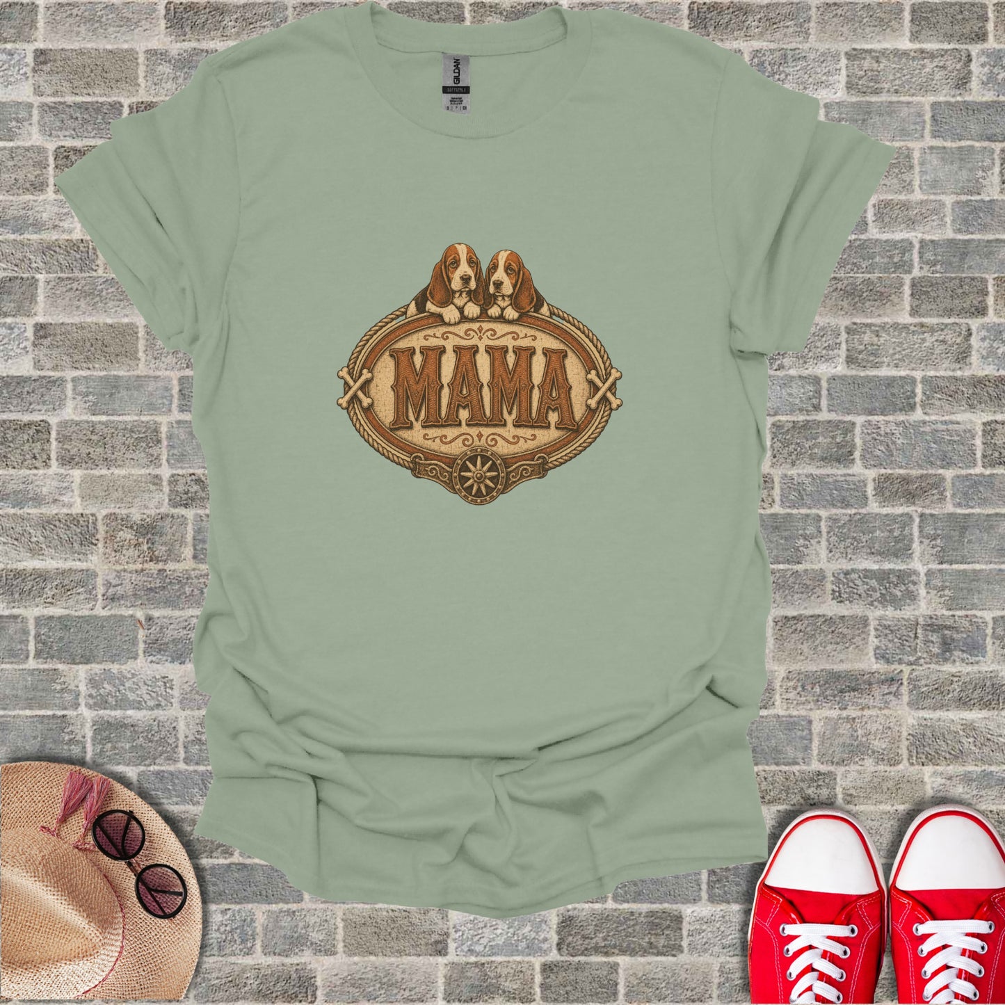 Green t-shirt with "Mama" in a rope-edged oval frame above two puppies.