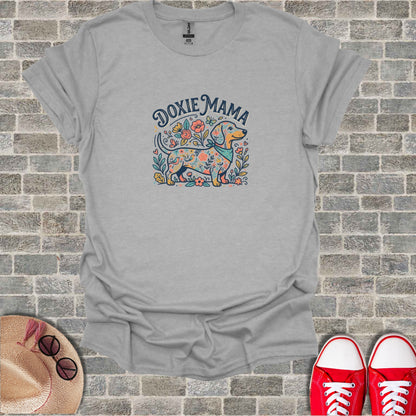 Dachshund with flowers and "Doxie Mama" text on a grey t-shirt.