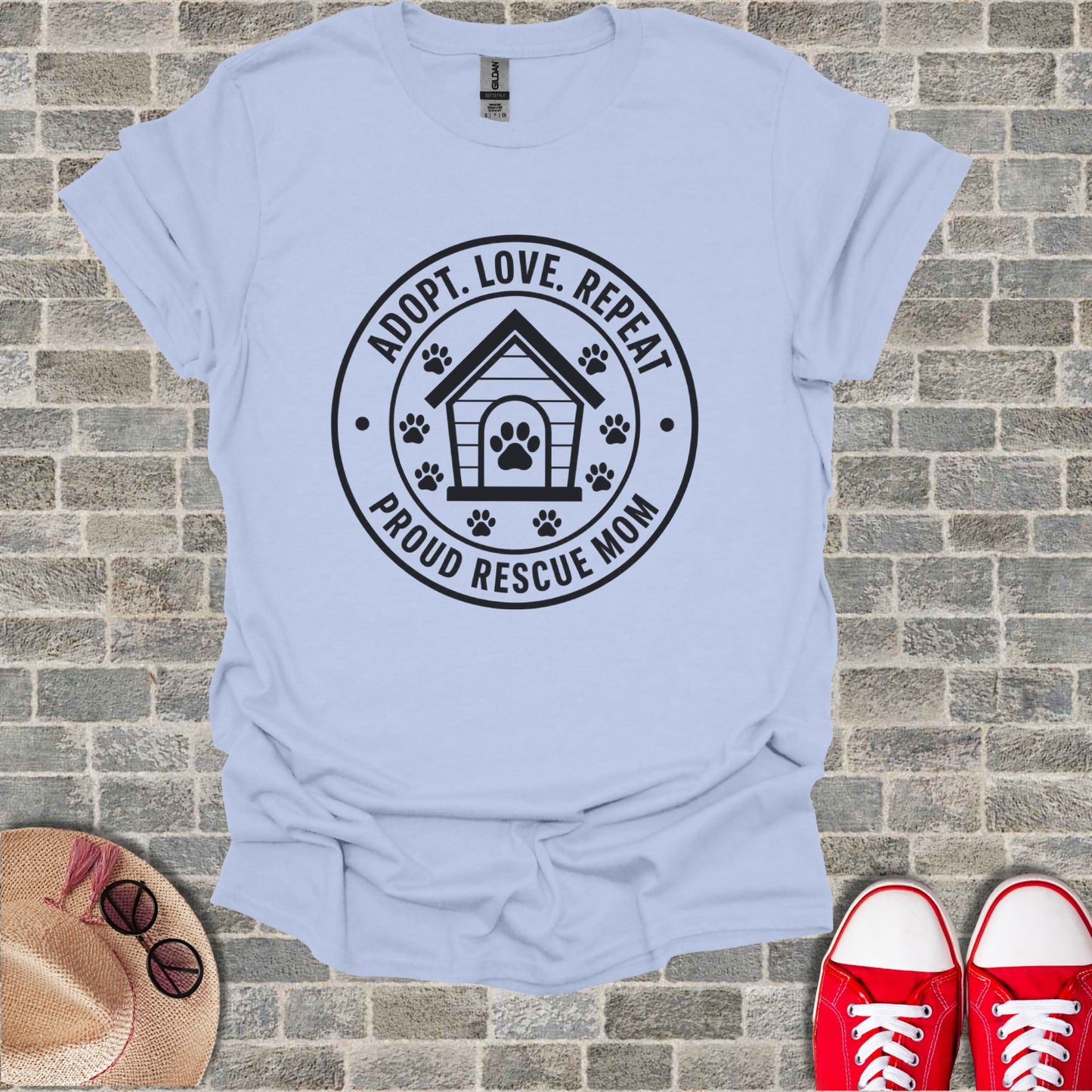 Light blue t-shirt with black circular graphic: "ADOPT. LOVE. REPEAT." and "PROUD RESCUE MOM".