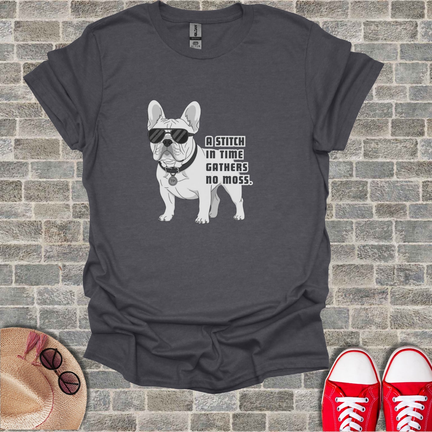 French bulldog wearing sunglasses and collar on t-shirt, "A stitch in time gathers no moss."