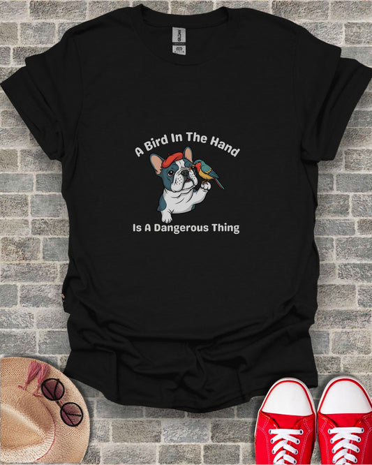 Black t-shirt with French bulldog wearing a red bandana, holding a small bird. Text: A Bird In The Hand Is A Dangerous Thing.