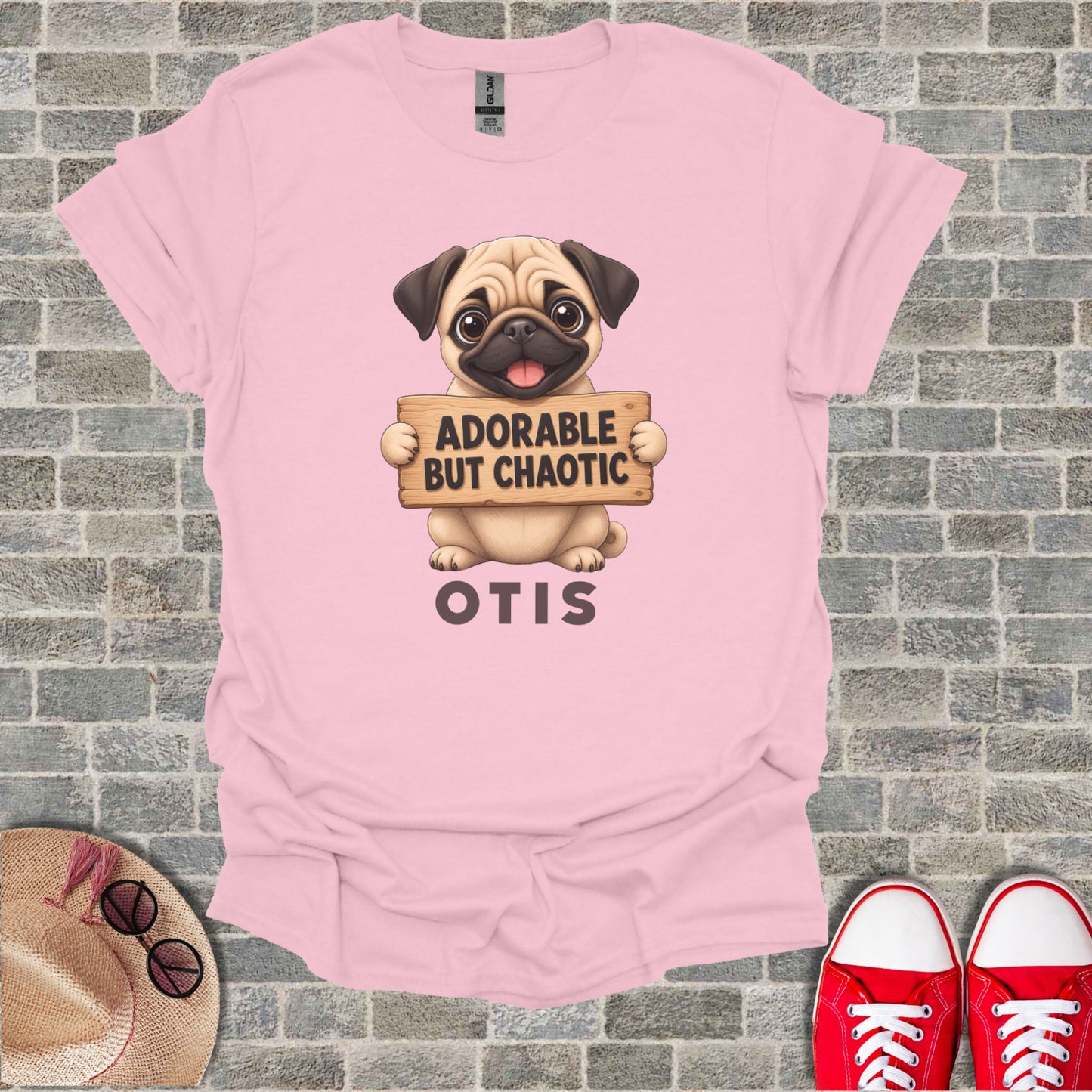 Pink t-shirt with pug graphic that reads "ADORABLE BUT CHAOTIC OTIS".