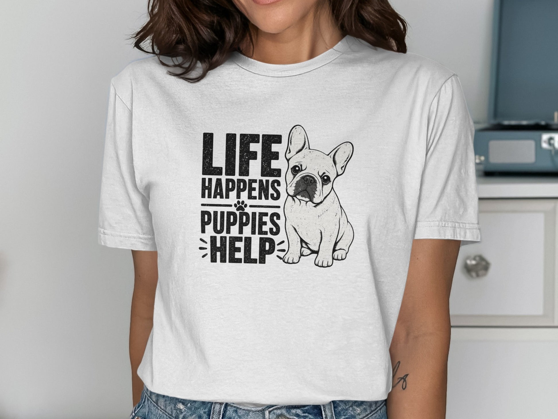 White t-shirt with black text "LIFE HAPPENS PUPPIES HELP" and French Bulldog graphic.