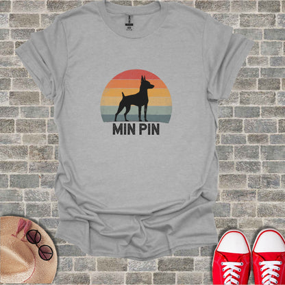 Grey t-shirt with a black silhouette of a Miniature Pinscher against a vintage sunset and "MIN PIN" text.