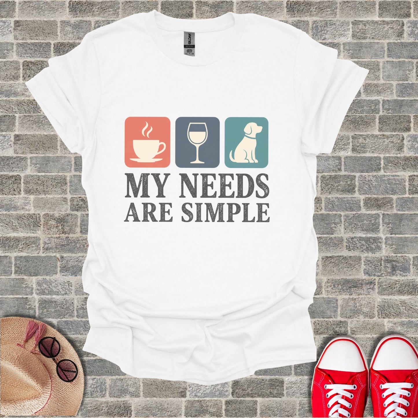 White t-shirt with coffee, wine glass, and dog icons and text "MY NEEDS ARE SIMPLE".