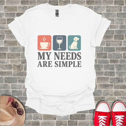 White t-shirt with coffee, wine glass, and dog icons and text "MY NEEDS ARE SIMPLE".