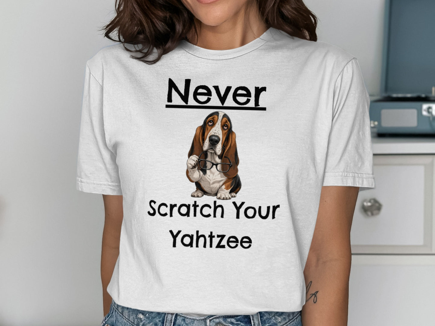 White t-shirt with "Never Scratch Your Yahtzee" and a basset hound wearing glasses.
