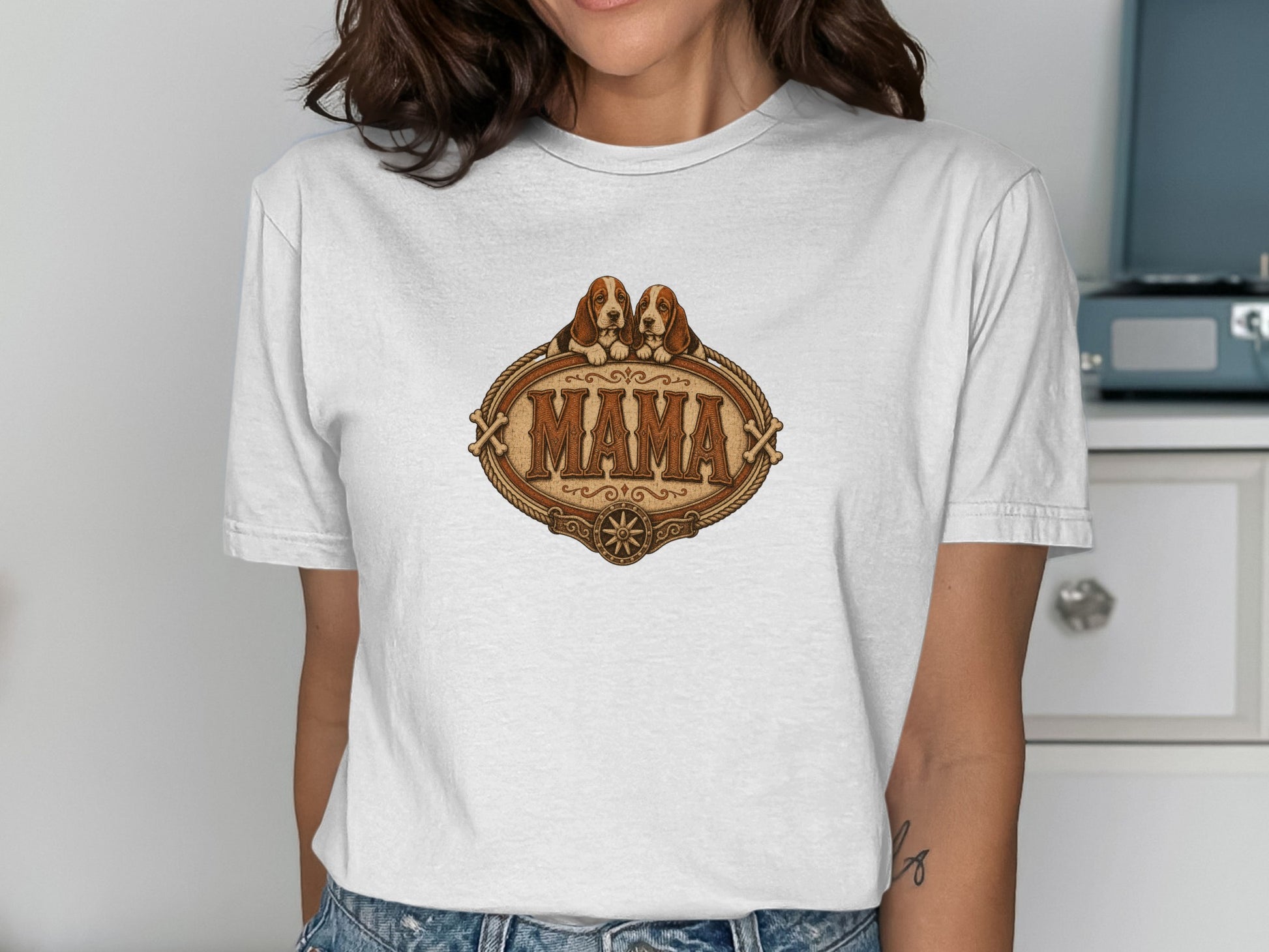 White t-shirt with a distressed oval graphic featuring two basset hounds above the text "MAMA".
