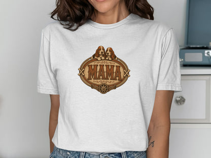 White t-shirt with a distressed oval graphic featuring two basset hounds above the text "MAMA".