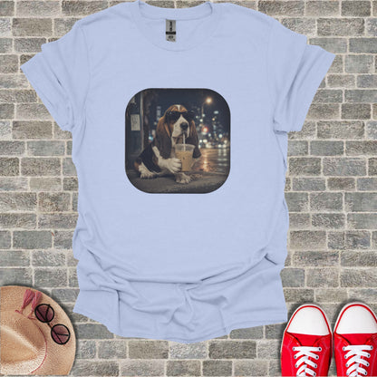 Basset hound wearing sunglasses drinks iced coffee on a city street at night.