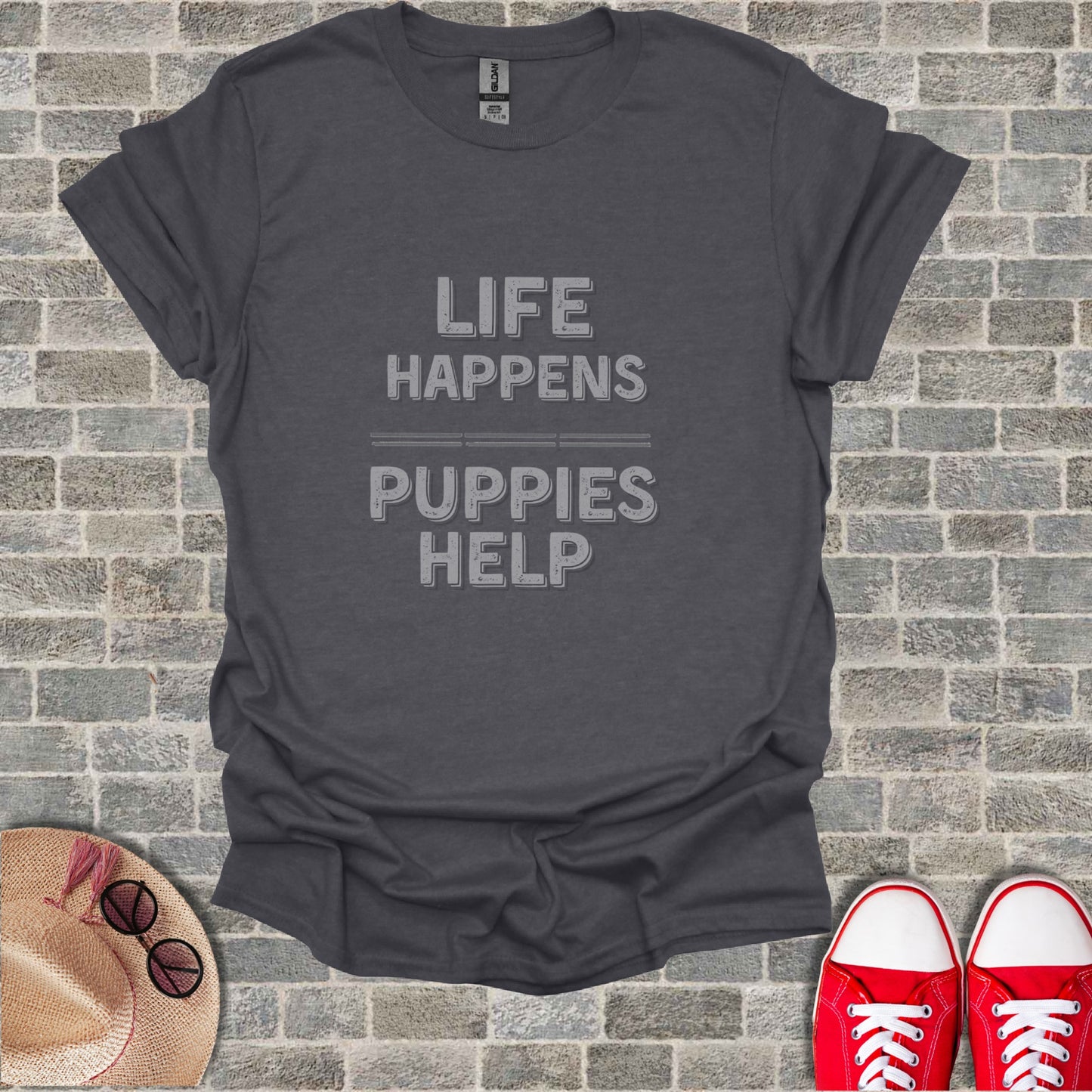 Dark gray t-shirt with "LIFE HAPPENS PUPPIES HELP" printed in textured gray font.