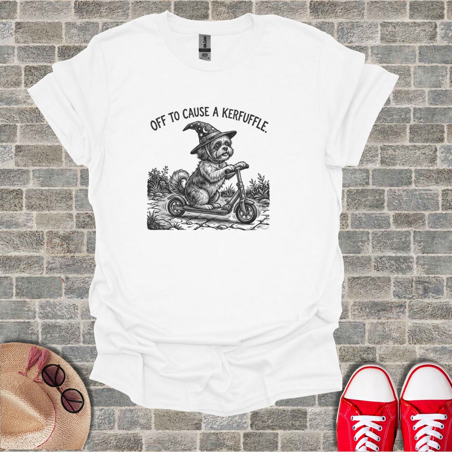 T-shirt with drawing of a dog in a witch hat riding a scooter.