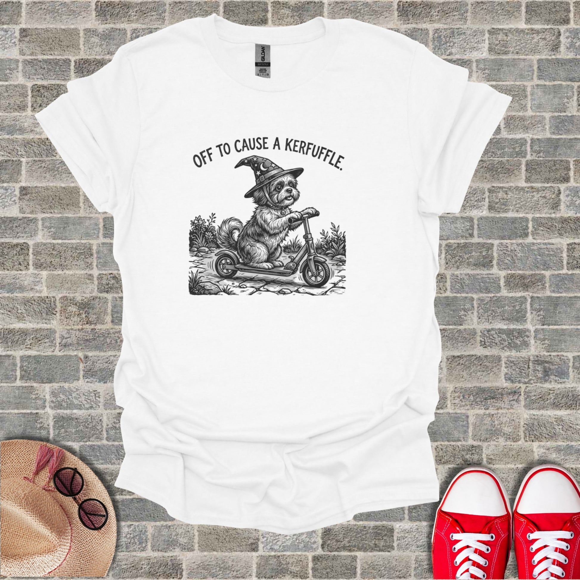 T-shirt with drawing of a dog in a witch hat riding a scooter.