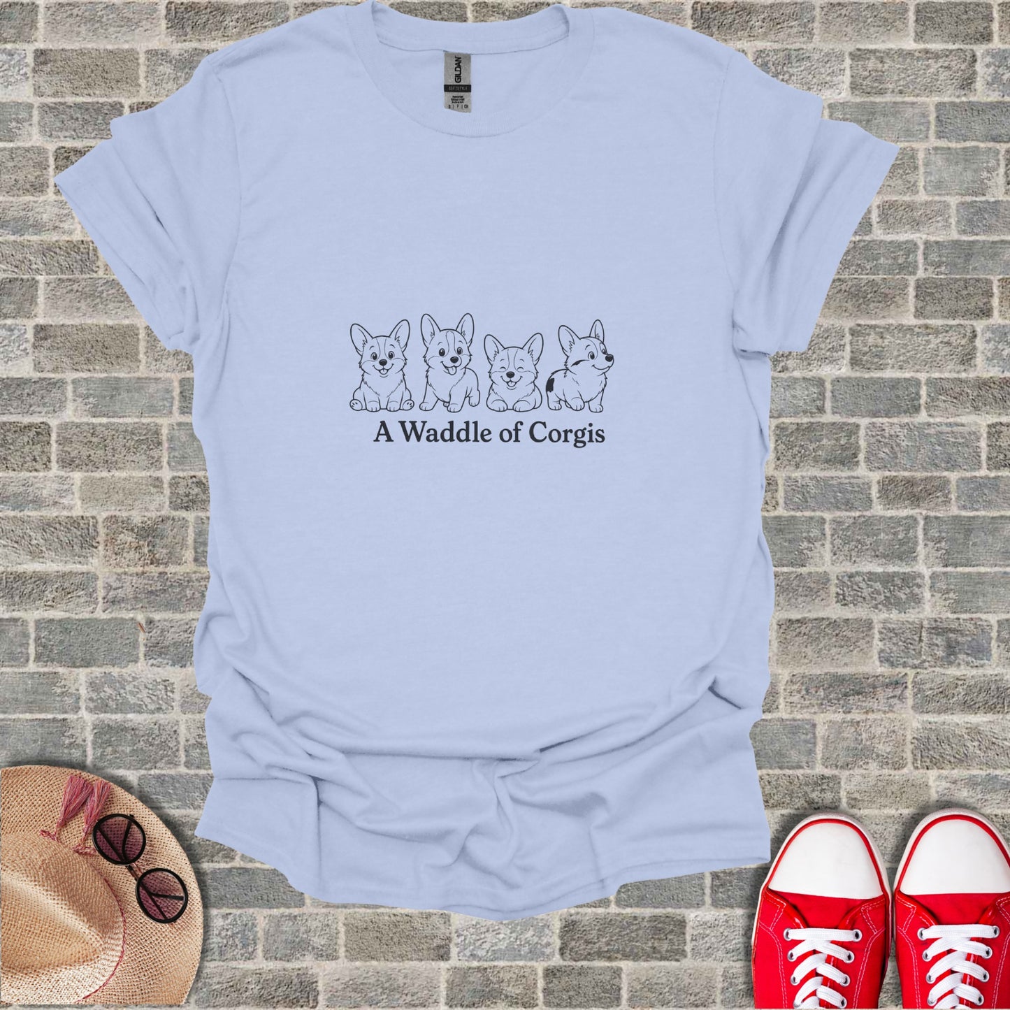 Line art of four corgis with text "A Waddle of Corgis" on a light blue t-shirt.