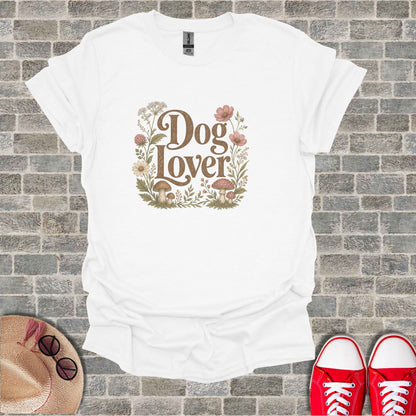 White t-shirt with "Dog Lover" text surrounded by floral and mushroom illustrations.