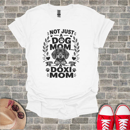 White t-shirt with dachshund graphic and text "NOT JUST A DOG MOM... A DOXI MOM".