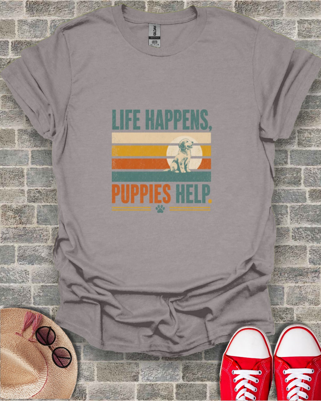 Grey t-shirt with text "LIFE HAPPENS, PUPPIES HELP" and a puppy illustration.