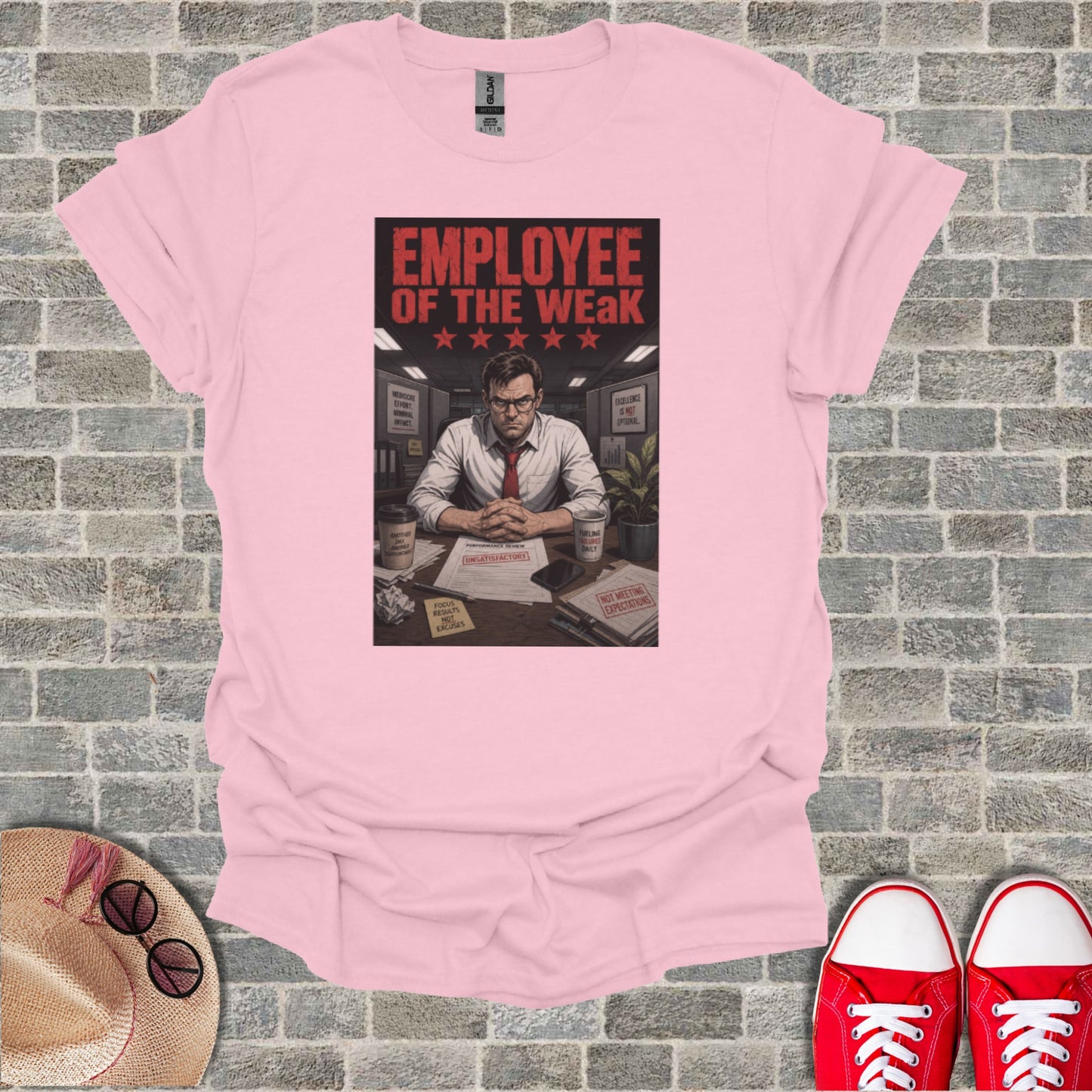 T-shirt graphic: "Employee of the Weak" with motivational posters and a desk.
