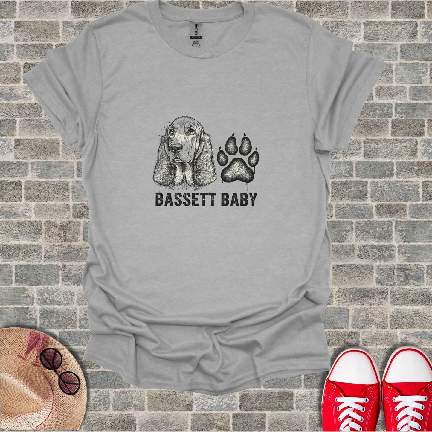 Grey t-shirt with "BASSETT BABY" text and a sketched basset hound and paw print.