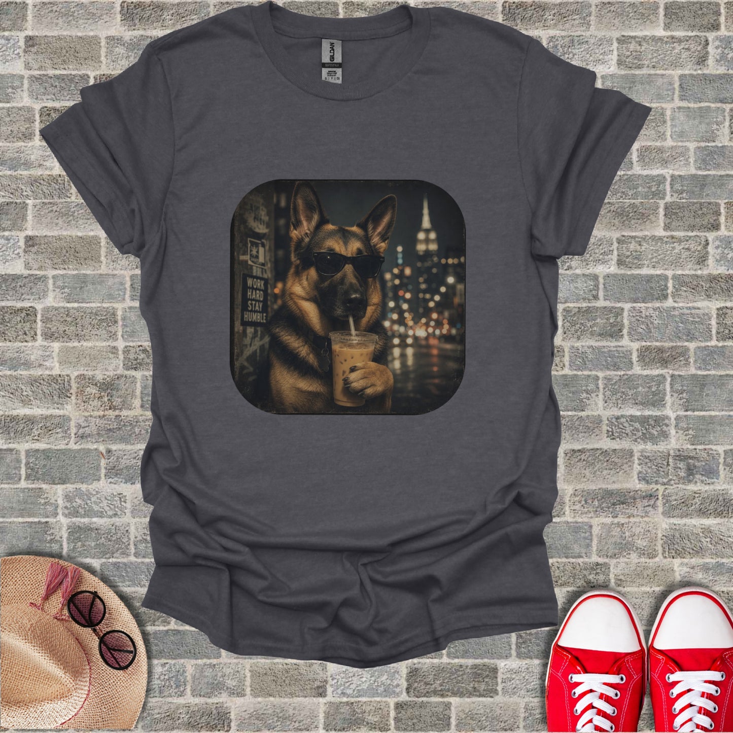 German Shepherd wearing sunglasses drinks iced coffee in front of city lights.