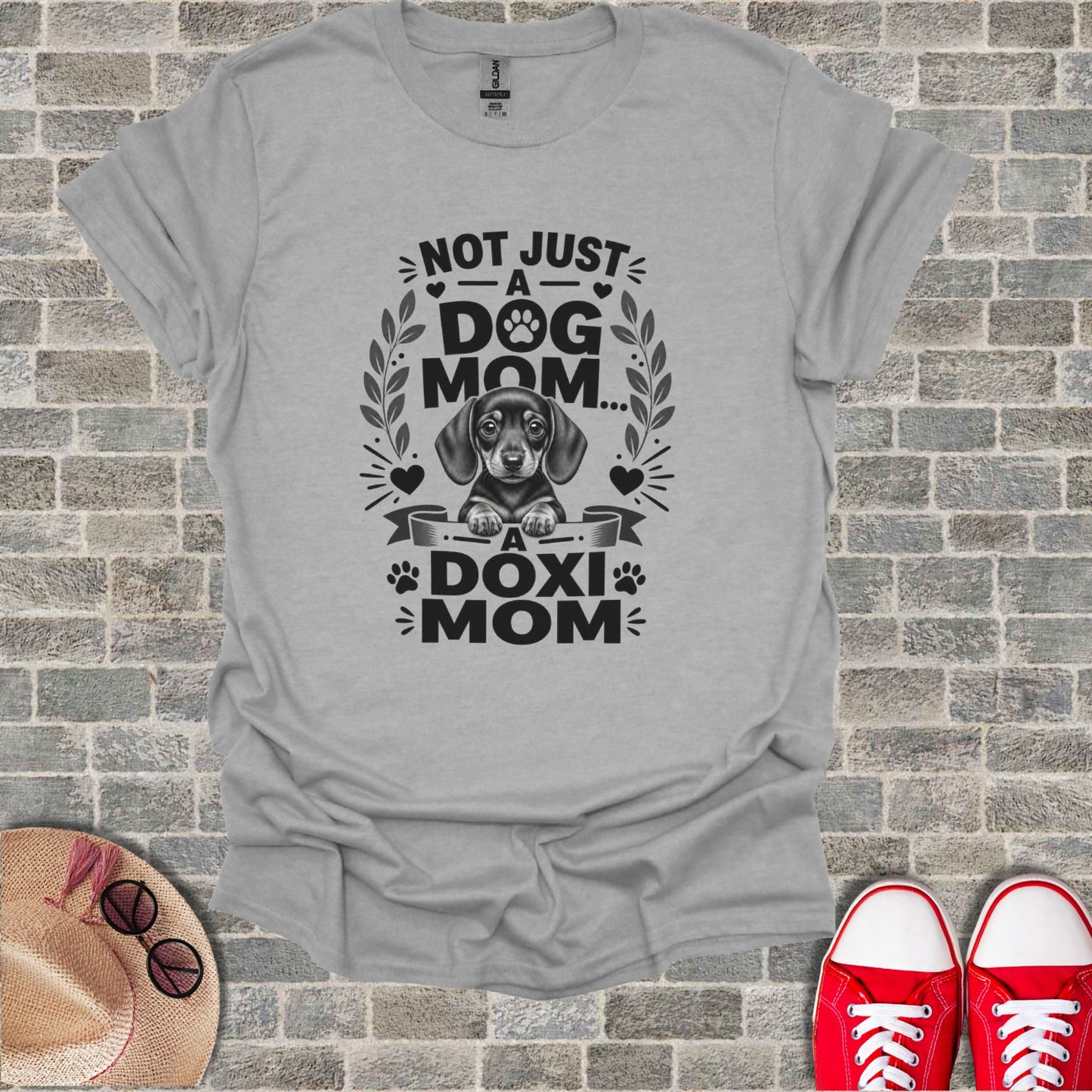 Grey t-shirt with text "Not Just A Dog Mom... A Doxi Mom" and dachshund graphic.
