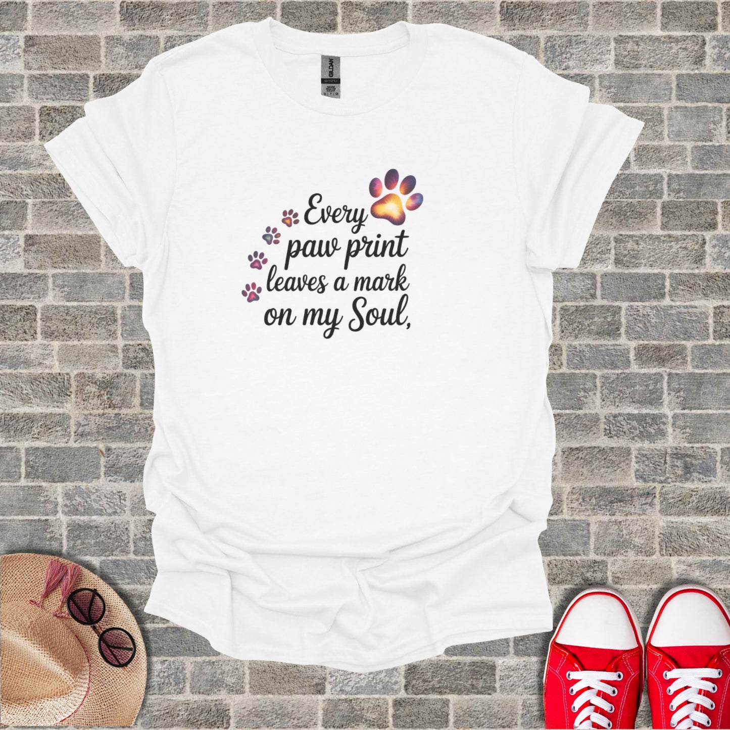 White t-shirt with "Every paw print leaves a mark on my Soul" text and paw prints.