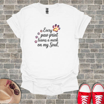 White t-shirt with "Every paw print leaves a mark on my Soul" text and paw prints.