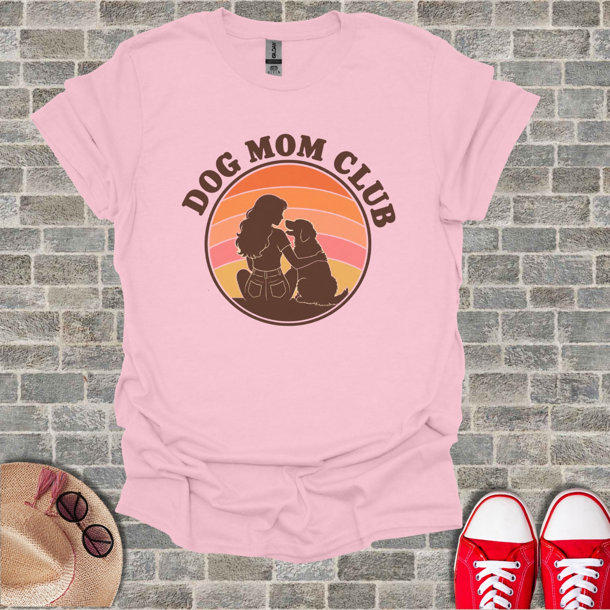 Pink t-shirt with "Dog Mom Club" graphic of a woman and dog in a sunset circle.