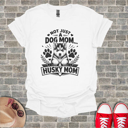 White t-shirt with text "Not Just A Dog Mom... A Husky Mom" and husky puppy graphic.