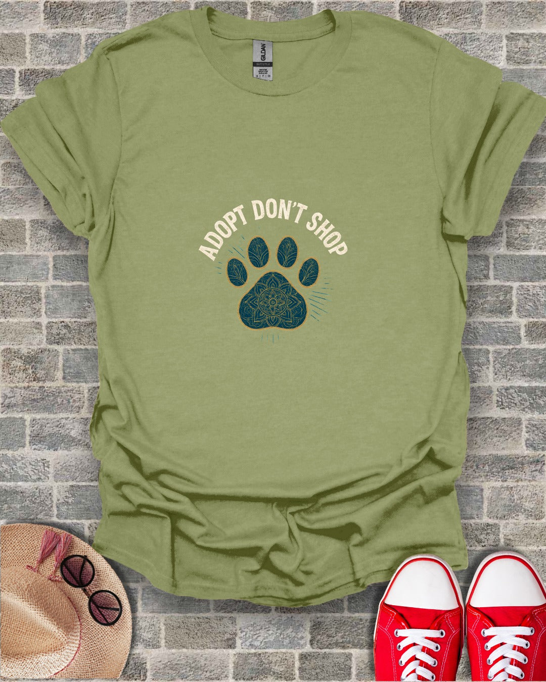 Olive green t-shirt with "Adopt Don't Shop" and paw print design.