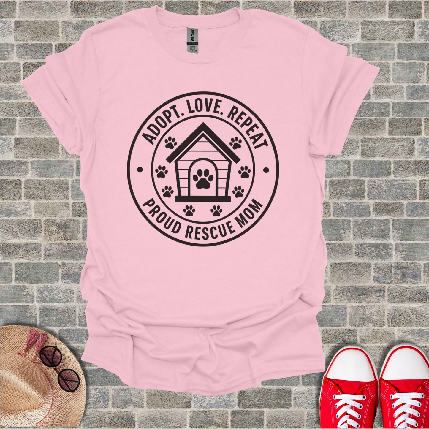 Pink t-shirt with "Adopt. Love. Repeat. Proud Rescue Mom" text and paw prints.