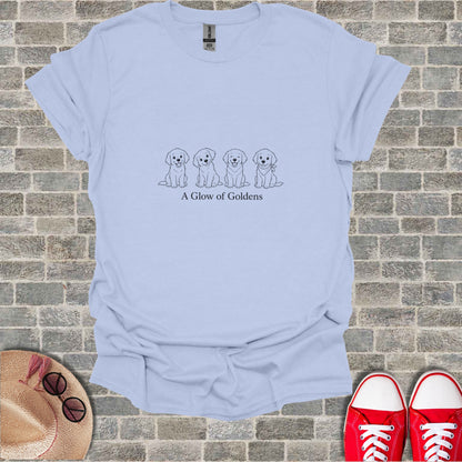 Light blue t-shirt with four cartoon golden retrievers and text "A Glow of Goldens".