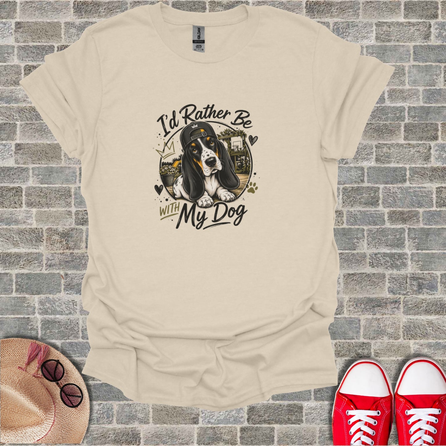 T-shirt graphic of a basset hound wearing a backward baseball cap, with "I'd Rather Be With My Dog" text.