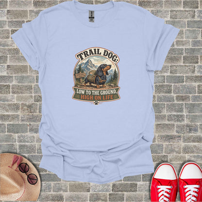 T-shirt with "Trail Dog: Low to the Ground, High on Life" text and mountain graphic.