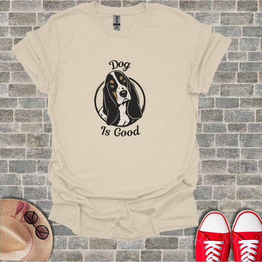 Basset hound wearing glasses and shirt reading "Dog Is Good."