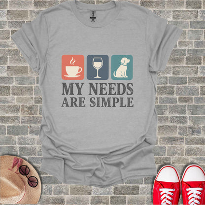 Light grey t-shirt with icons of coffee, wine, dog and text "MY NEEDS ARE SIMPLE".