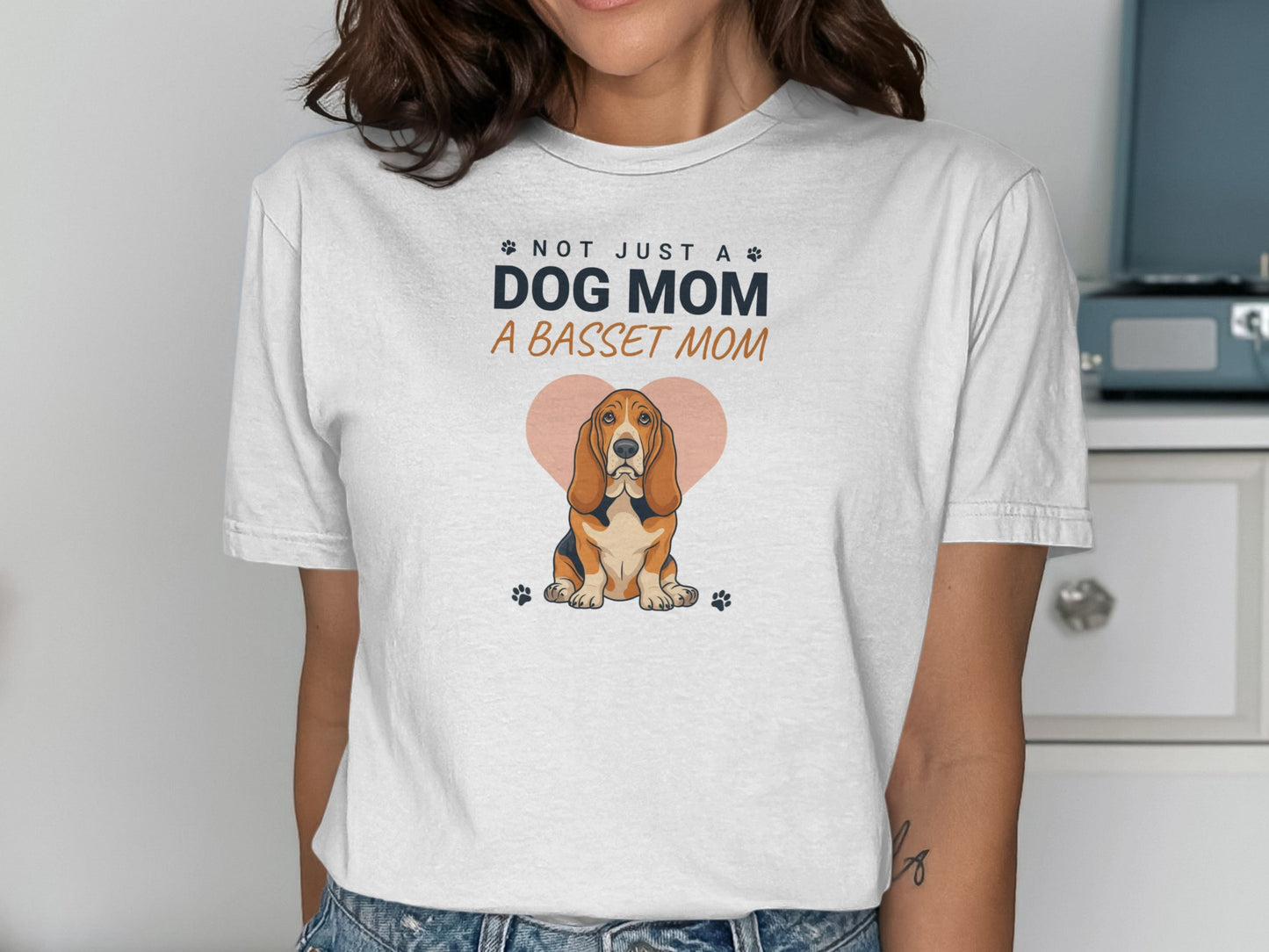 White t-shirt with "Not Just a Dog Mom, A Basset Mom" text and basset hound.