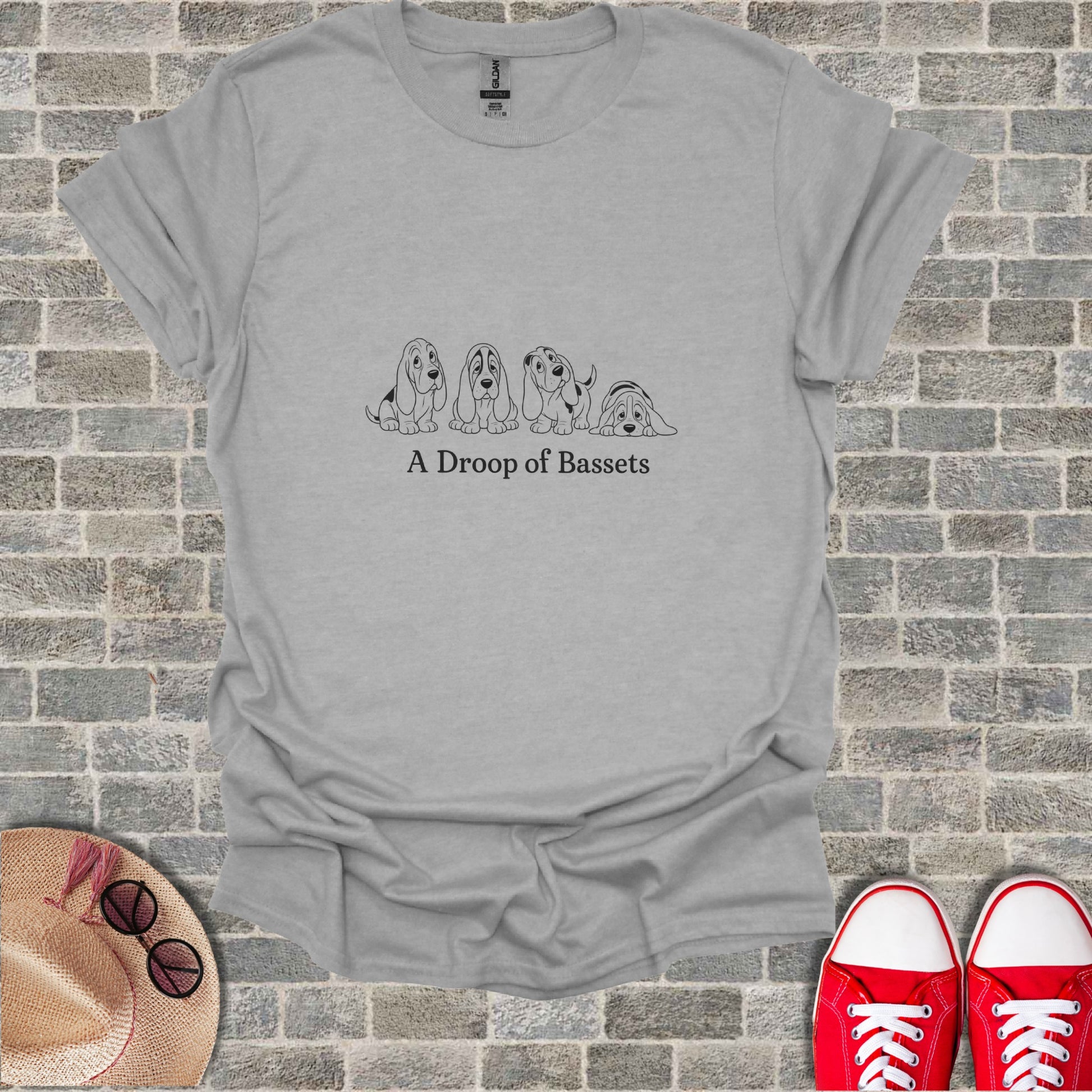 Line art of four droopy Basset Hounds on a grey t-shirt.
