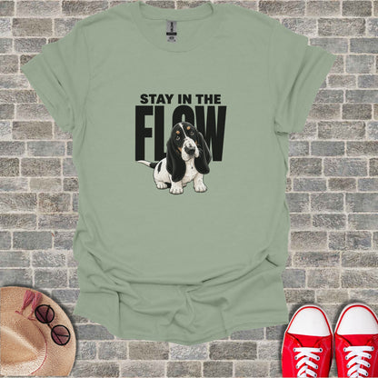 Basset Hound with "STAY IN THE FLOW" text on a light green t-shirt.