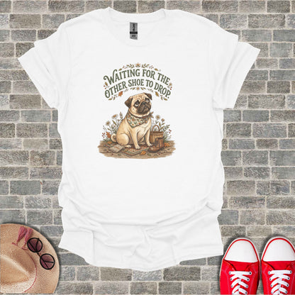 White t-shirt with a pug wearing a bandana, sitting among flowers and boots.