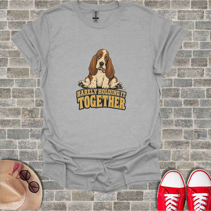 T-shirt with a cartoon Basset Hound looking tired, text says "BARELY HOLDING IT TOGETHER".