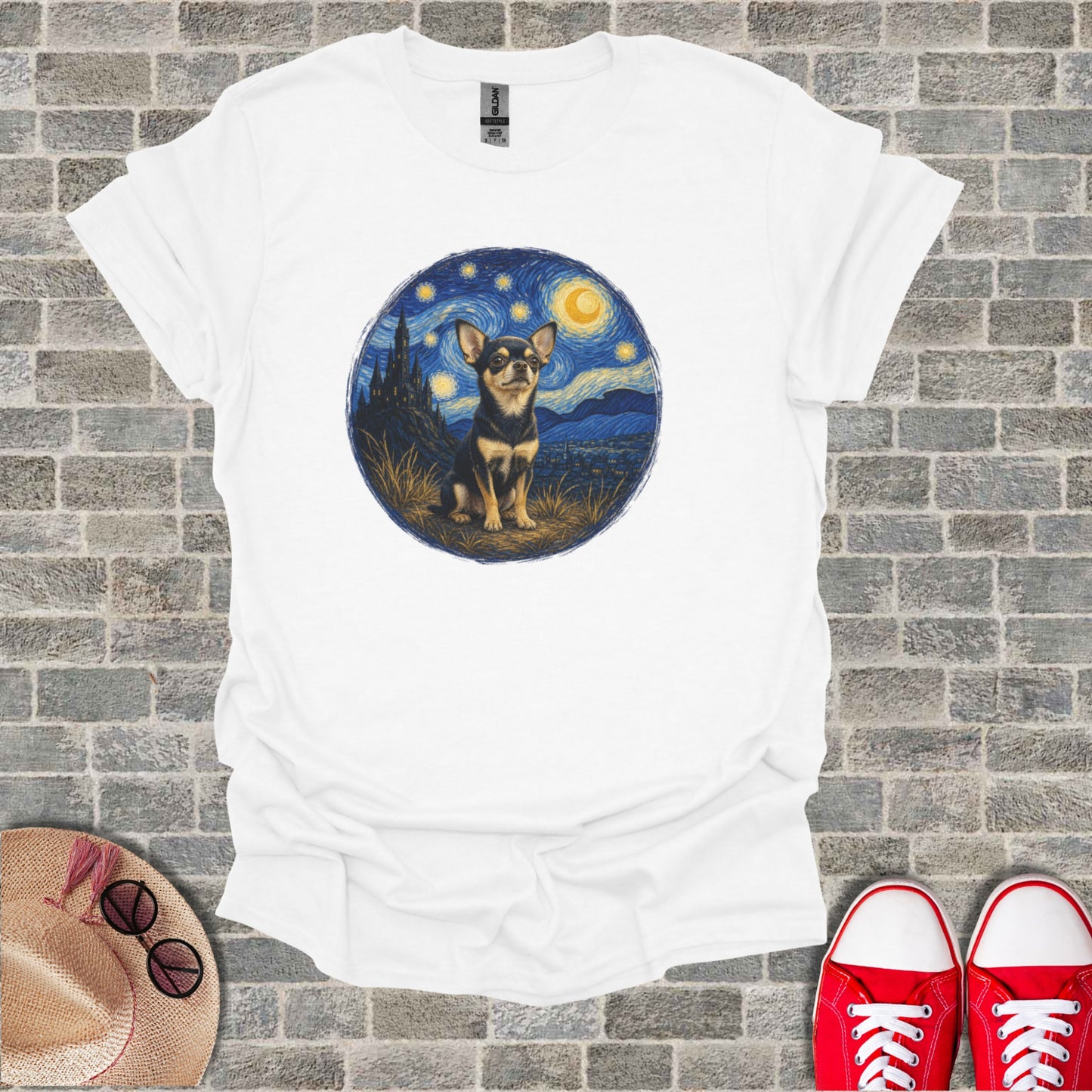 Chihuahua sits in a starry night landscape on a white t-shirt.