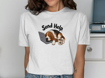 Basset hound asleep on laptop with coffee cup.