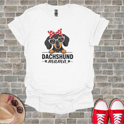 White t-shirt with "Dachshund mama" and a graphic of a dachshund wearing glasses and a bow.