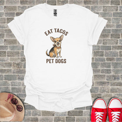 White t-shirt with chihuahua wearing bandana and text "EAT TACOS PET DOGS".