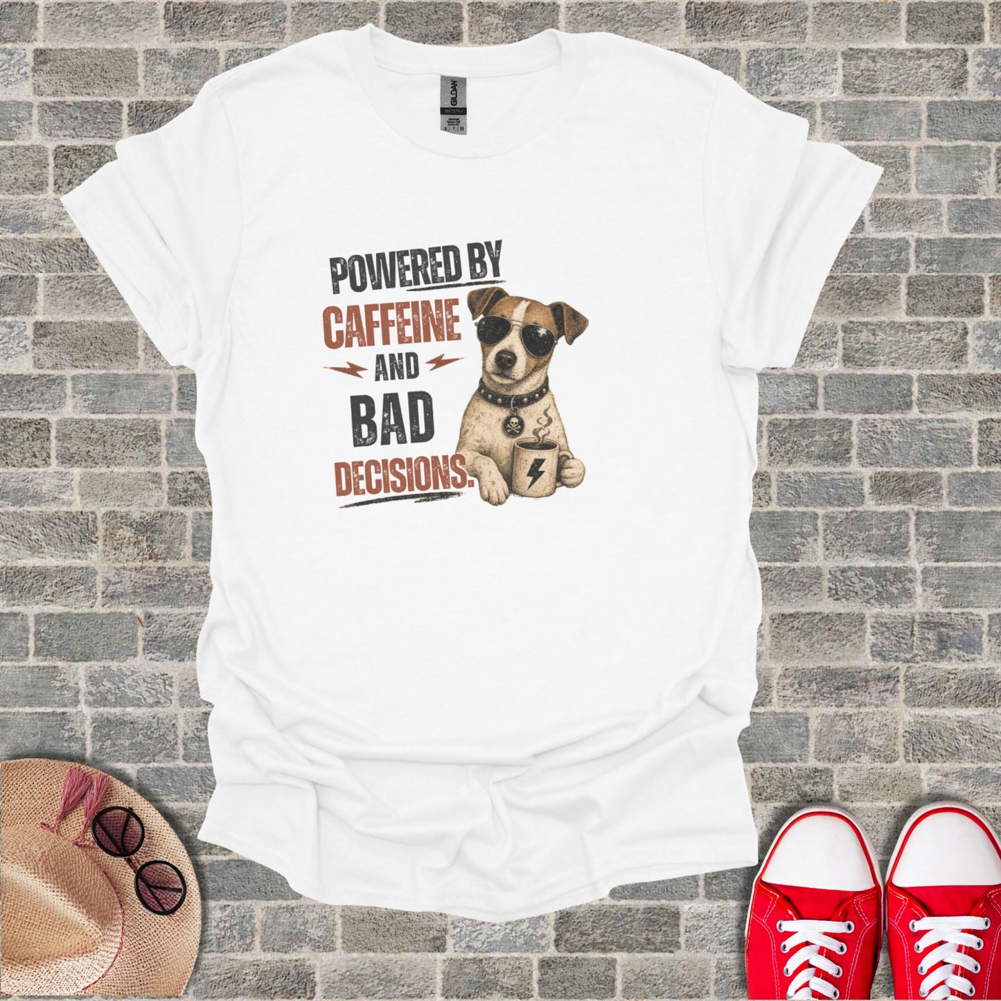 White t-shirt with cartoon dog wearing sunglasses holding coffee cup, text "POWERED BY CAFFEINE AND BAD DECISIONS."