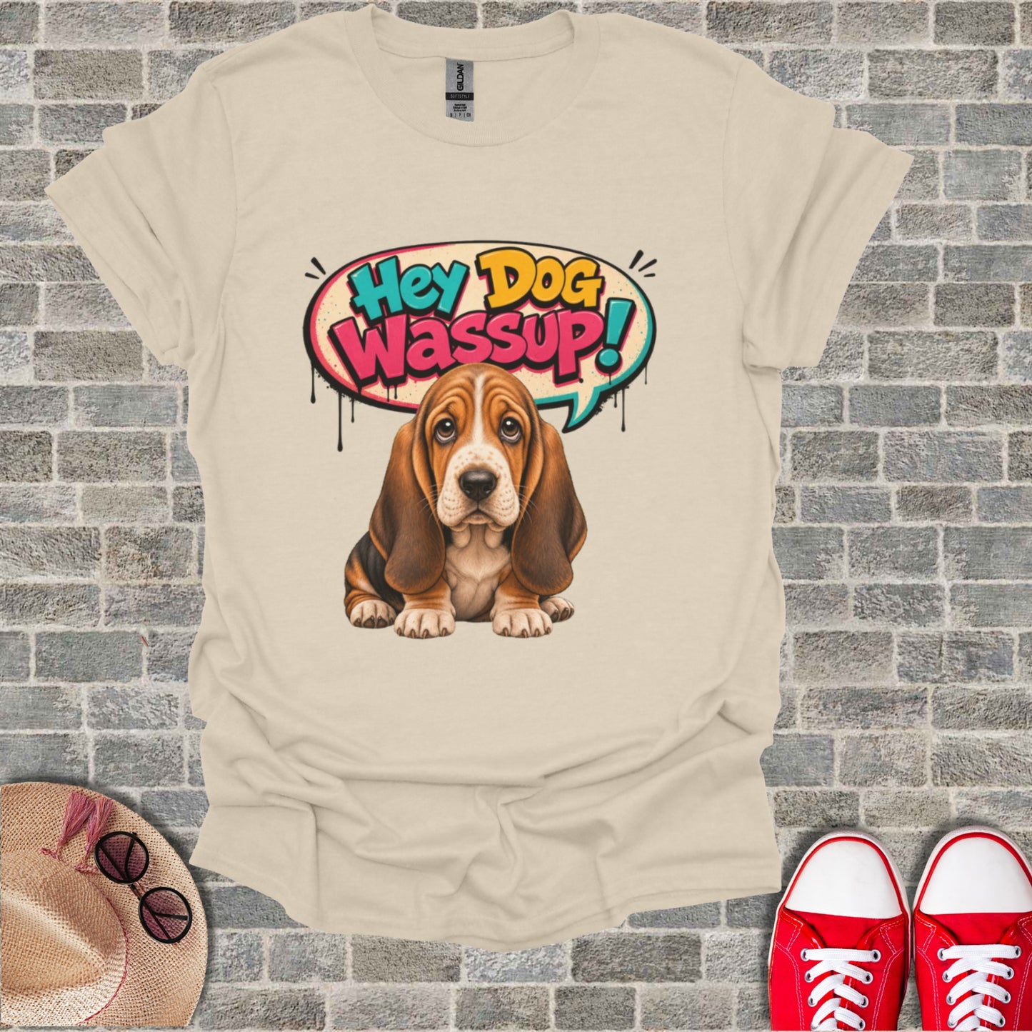 Basset Hound puppy with speech bubble saying "Hey Dog Wassup!" on tan t-shirt.