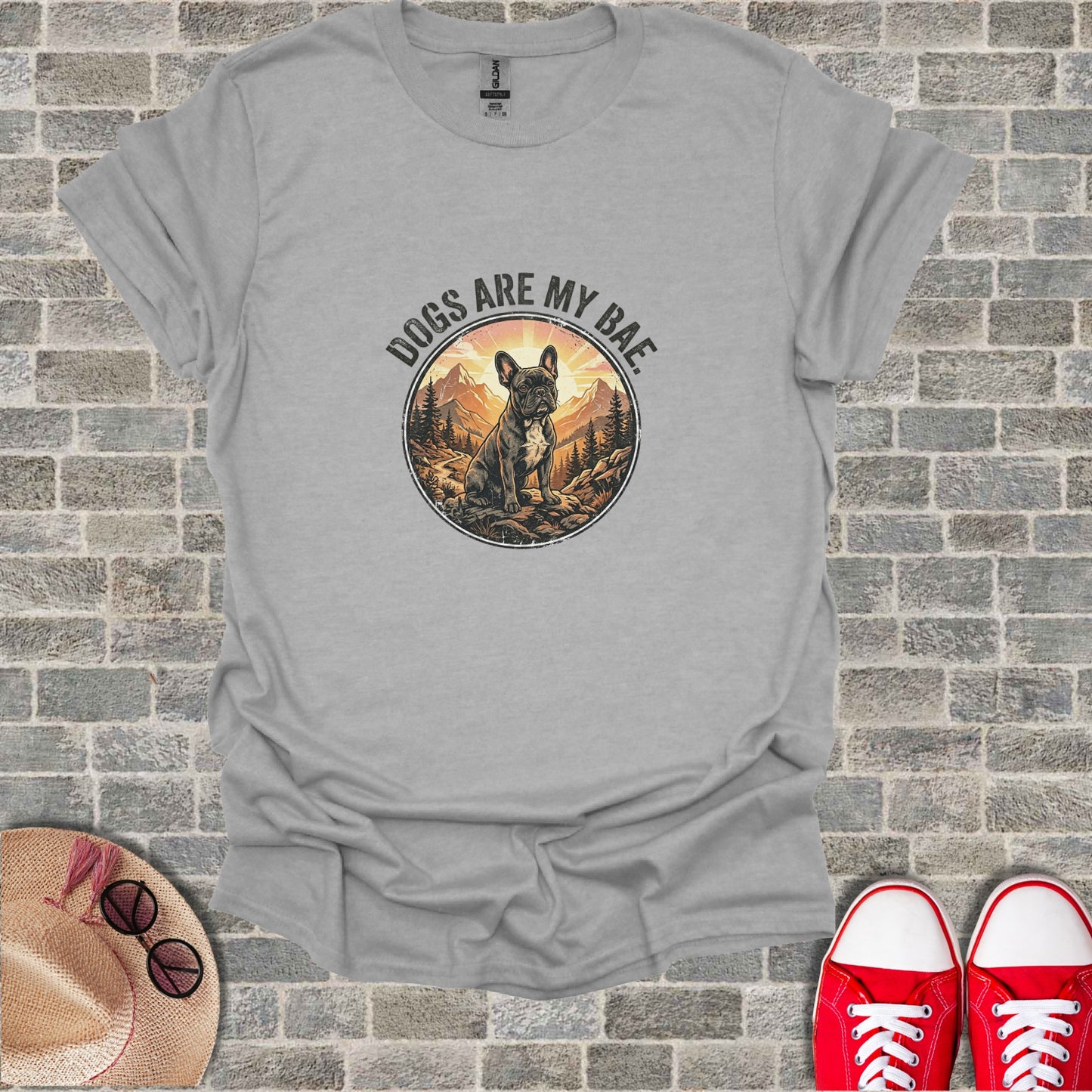 French bulldog in a circular frame with "Dogs are my bae" text, mountains and sun.