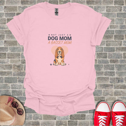 Light pink t-shirt with "Not Just a Dog Mom A Basset Mom" text and Basset Hound graphic.